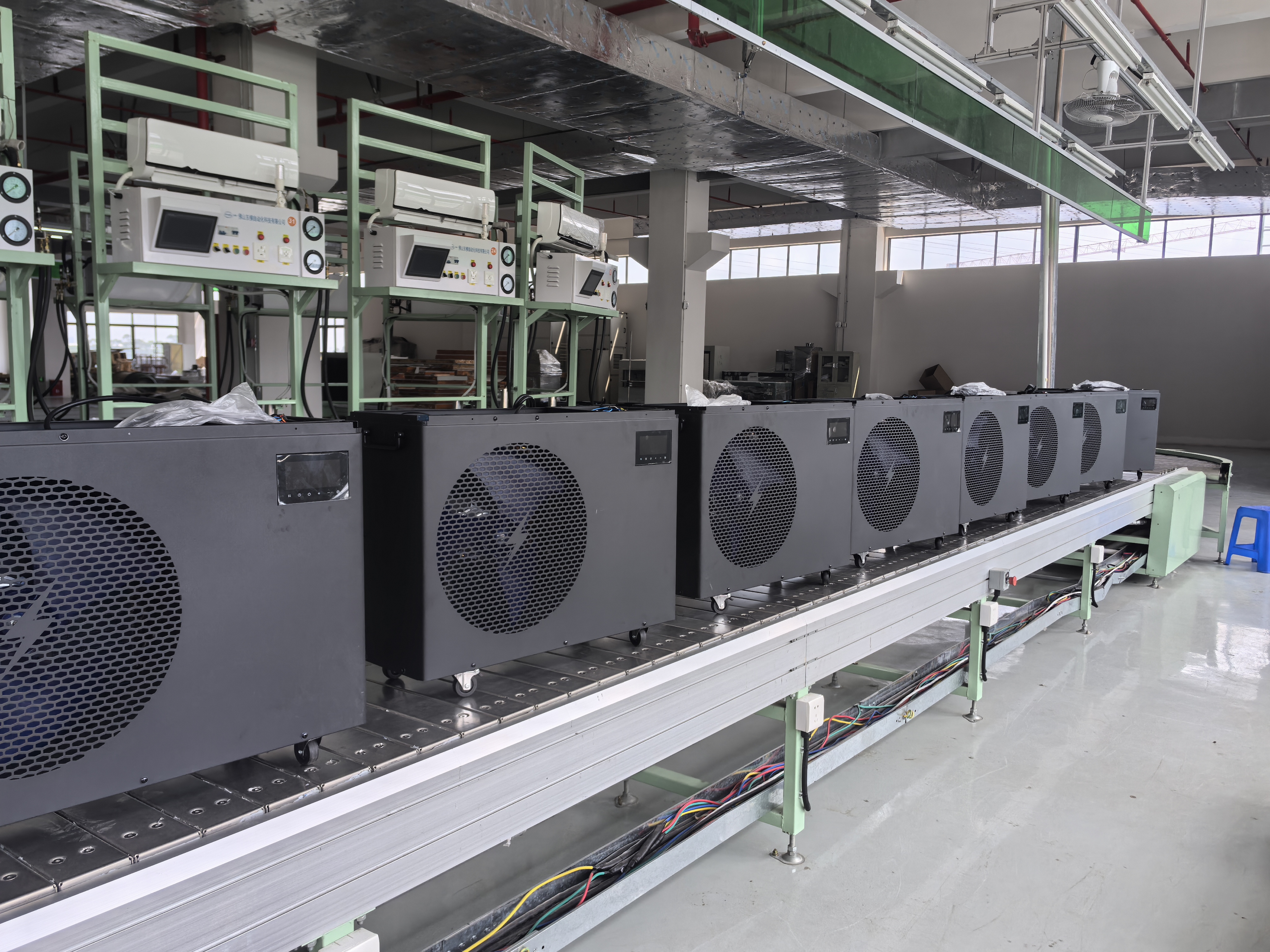 Chiller housings receding along the assembly conveyor beneath workstation screens