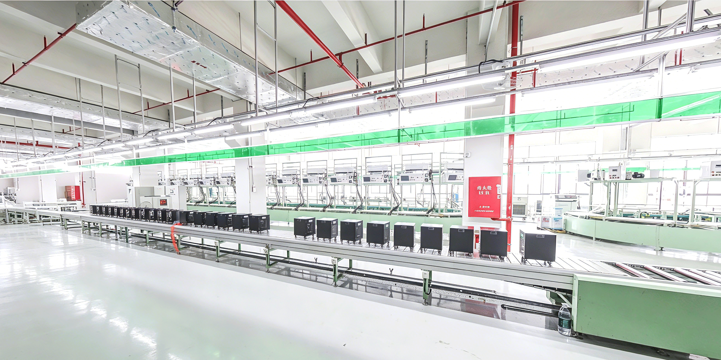 Wide workshop view with chiller units along the conveyor and workstations beyond